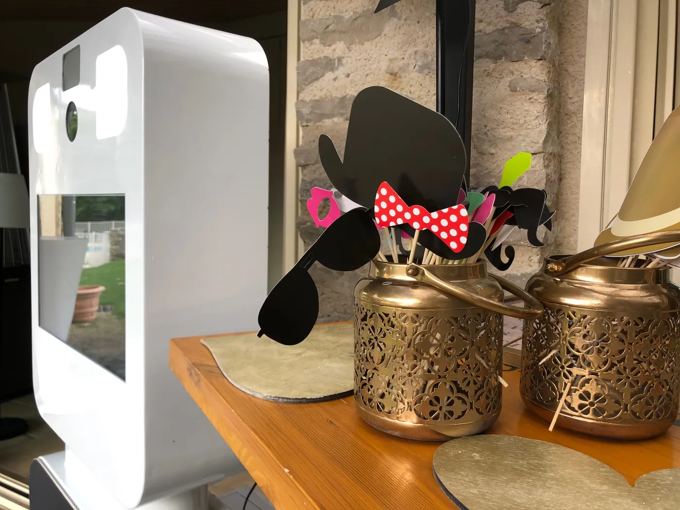 accessoires photobooth : chapeau, moustaches, lunettes et nœud papillon à côté de la borne