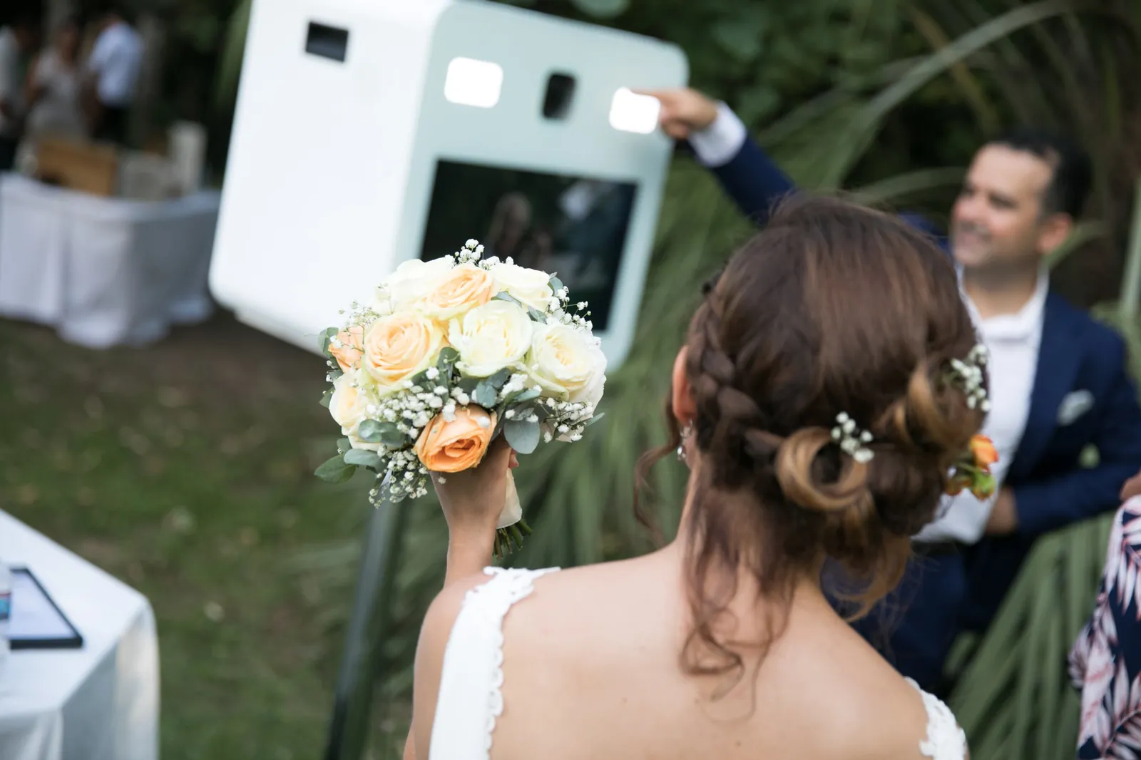 mariée posant avec son bouquet devant le photobooth